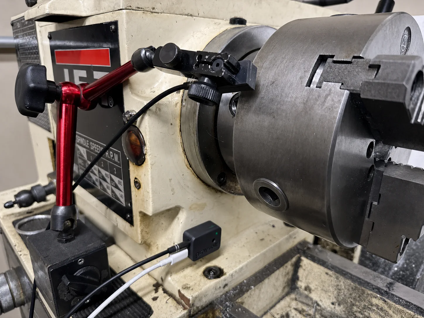 GrayVolt vibration analyzer and optical tach mounted on a dial indicator stand beside a JET lathe